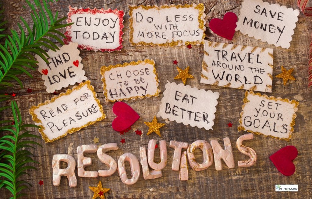 Handwritten resolution notes on a wooden background reading phrases like “enjoy today,” “do less with more focus,” and “choose to be happy,” symbolizing intentional action and personal growth.